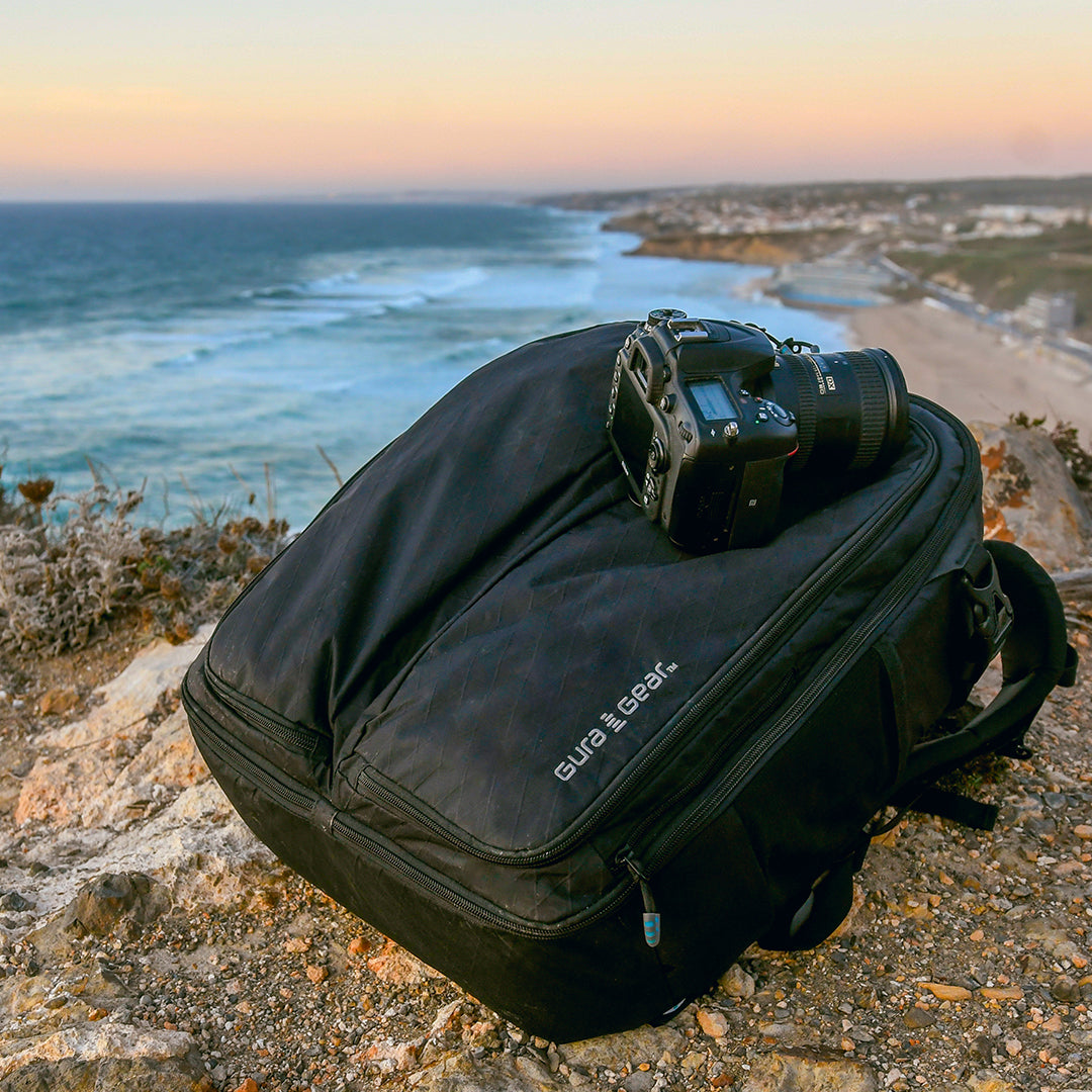 A black Kiboko 2.0 22L+ on a coastal cliff with a camera resting on top