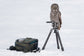 A Forest Green Kiboko 2.0 30L+ open on the snow beside a tripod with a great grey owl perched on it
