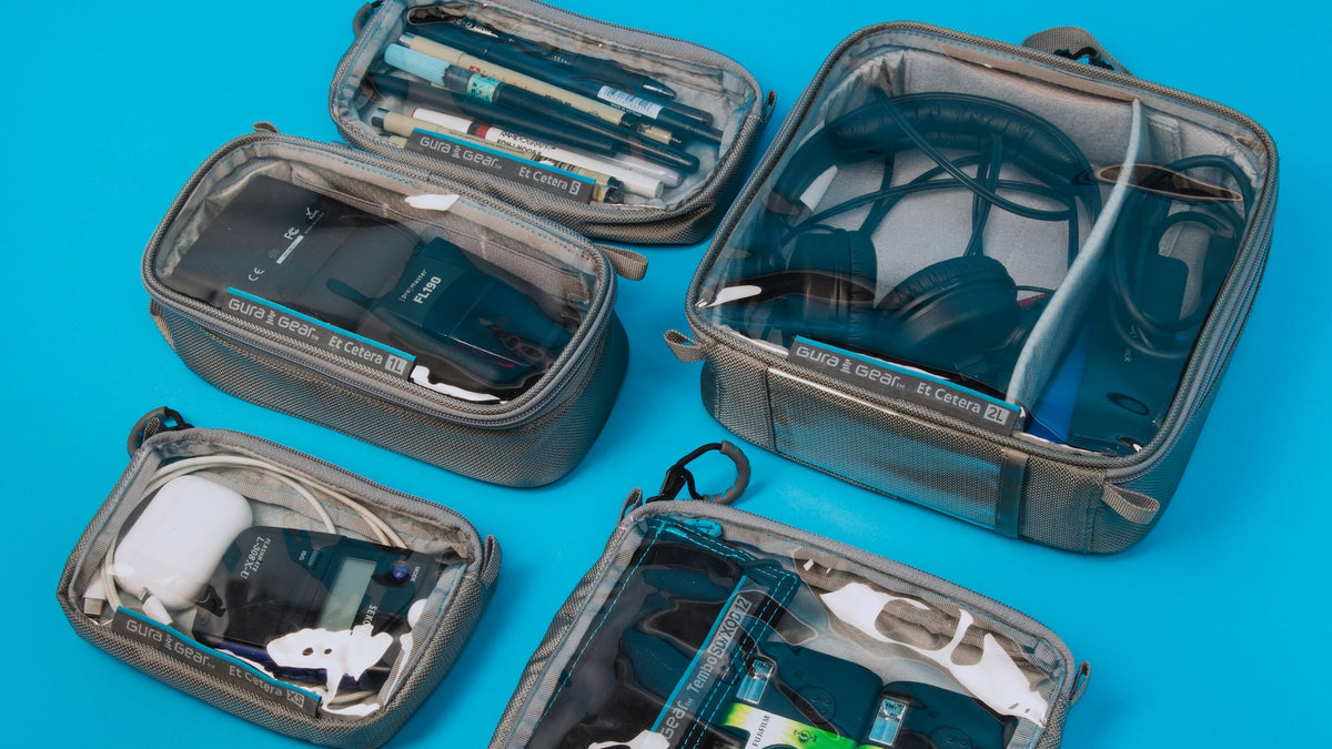 Gura Gear Et Cetera see-through cases packed with cables, headphones and small accessories on a blue background